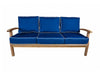 A luxurious Tortuga Outdoor 6-Piece Indonesian Teak Sofa and Fire Table Set - Canvas Natural or Navy featuring a blue sofa with wooden legs and cushions.