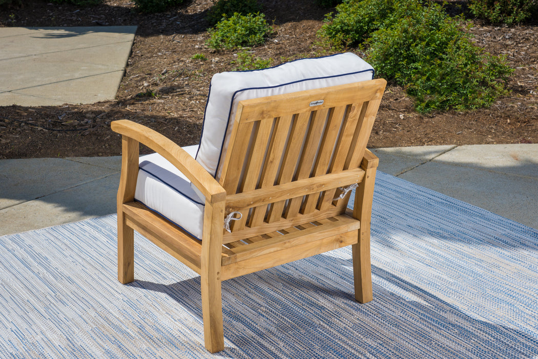 A durable Tortuga Outdoor teak dining chair on a rug, perfect for outdoor patios.