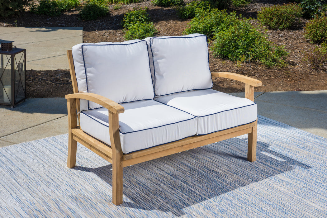 A durable Tortuga Outdoor 5-Piece Indonesian Teak Loveseat Set with Sunbrella Canvas Natural or Navy cushions on a rug.