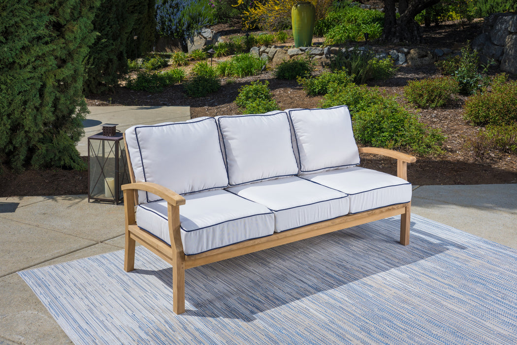 A durable Tortuga Outdoor 5-Piece Indonesian Teak Sofa Set with Sunbrella Canvas Natural or Navy cushions on a rug.