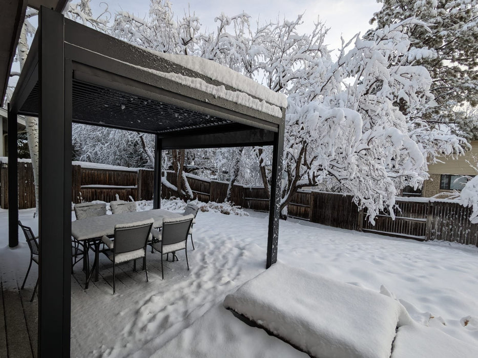 A Luxury Aluminum Shade Pergola covered in snow with a table and chairs.