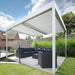 An outdoor Bon Pergola patio with a white canopy and black furniture.